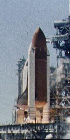 Black smoke from the Solid Rocket Booster on the left (in this image) obscures the orange of the external tank near the bottom of the tank.