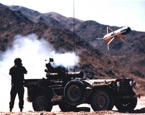 A TOW missile being fired from a Jeep. A small charge boosts the missile clear of the launcher before the rocket motor ignites -- fortunately for the soldier standing next to it!