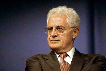 Lionel Jospin has white, curly hair and wears glasses. He's generally seen with a suit and a tie.