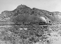 The train pictured is the Jupiter which carried Leland Stanford, one of the "big four" owners of the Central Pacific, and other railway officials to the Golden Spike Ceremony. Notice the Indians on the hill overlooking the train.