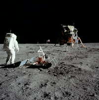 Aldrin stands next to the Passive Seismic Experiment Package with the  in the background.