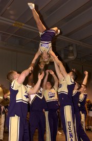 A cheerleader is flipped upside-down during a pep rally routine before a football game.