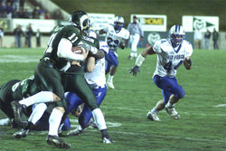A  player runs with the ball as an  player tries to thwart his progress.