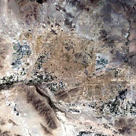 Phoenix is surrounded by twenty two towns and cities that have grown so closely together that it is almost impossible to distinguish one from another in this satellite image. The large cluster of light brown pixels gridded by horizontal and vertical lines (roads and highways) demarcates the Greater Phoenix urban area.