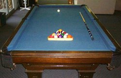 Pool table with cue ball, object balls, cue stick, and rack