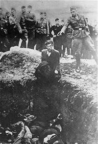 A member of Einsatzgruppe D prepares to murder a Jew kneeling before a filled mass grave in Vinnitsa, , in 1942.