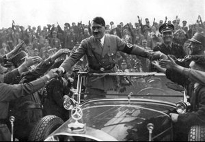 Adolf Hitler greeting supporters from aboard a parade vehicle
