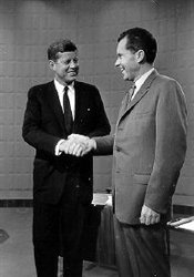 Kennedy shakes Richard Nixon's hand before a televised debate.