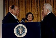Vice President  is sworn in as the 38th President of the United States by Chief Justice  as Mrs. Ford looks on.