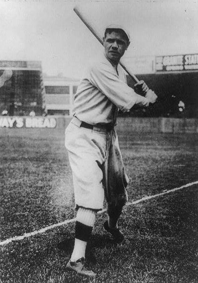 Babe Ruth, full-length portrait, standing, facing front, holding up bat, in baseball uniform, on field