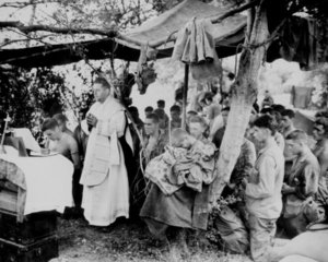 A Navy chaplain holds mass for Marines killed at Saipan, June 1944