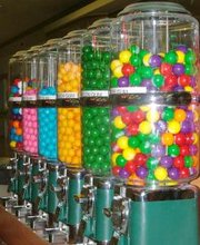 A rainbow-colored row of gumball machines.