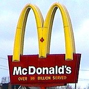 McDonald's trademark Golden Arches. The maple leaf indicates a Canadian location.