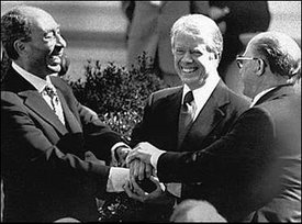  (left),  (center), and  (right) shake hands in celebration of the success of the Camp David Accords