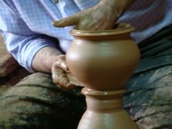 A man shapes pottery as it turns on a wheel. (Cappadocia, Turkey)