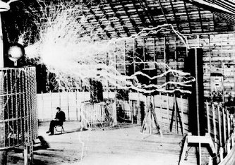 A publicity photo of Tesla sitting in the Colorado Springs experimental station with his "magnifying transmitter." The arcs are about 22 feet (7 m) long. (Tesla's notes identify this as a .)
