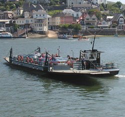 The Lower Kingswear to Dartmouth ferry, Devon, England. The pontoon carries eight cars and is towed across the River Dart by a small tug. Only two ropes connect the tug to the pontoon