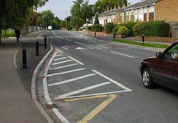 Two traffic calming measures in England:  (the two reddish pads in the road) and a  (marked by the black posts and white stripes)