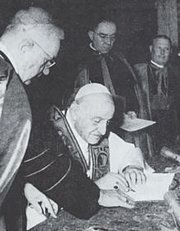 Pope John signing his encyclical Pacem in Terris.