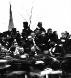 The only known photo of Lincoln at Gettysburg (seated), some three hours before he spoke. To the immediate left (Lincoln's right) is Lincoln's bodyguard, , and beyond the limits of this close-up is Governor  of . Taken about noontime, just after Lincoln arrived, before Edward Everett's arrival. (full view).