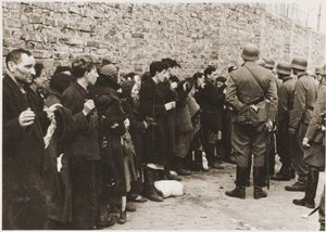 Captured inhabitants of the Ghetto await removal to the  for deportation.
