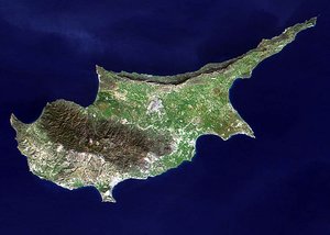 This image, acquired by NASA's Terra satellite on  , shows the three distinct geologic regions of the island. In the central and western part of the island is the Troodos Massif, a mountain range whose surface layer is mostly basaltic lava rock, and whose maximum elevation is 1953 m (6407 ft). Running in a thin arc along the northeast margin of the island is Cyprus's second mountain range, a limestone formation called the Kyrenia Range. The space between these ranges is home to the capital Nicosia, visible as a grayish-brown patch near the image's center.