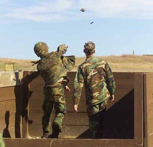 US Army grenade training includes practice throwing a dummy grenade. A hand grenade range instructor, right, observes. Photo: Walter Ludka.