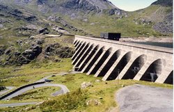 The upper reservoir and dam of the Ffestiniog Pumped-Storage Scheme in north .The power station at the lower reservoir has four water turbines which can generate 360 megawatts of electricity within 60 seconds of the need arising. The water of the upper reservoir (Llyn Stylan) can just be glimpsed on the right.